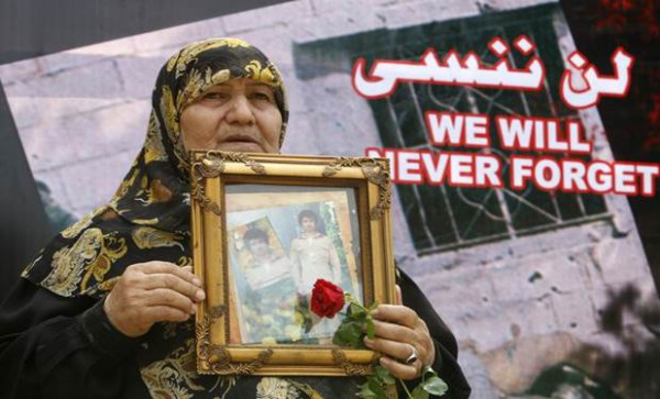 En la conmemoración de 2010 una mujer palestina lleva el retrato de un ser querido asesinado durante la masacre de Sabra y Chatila (Sharif Karim Reuters)
