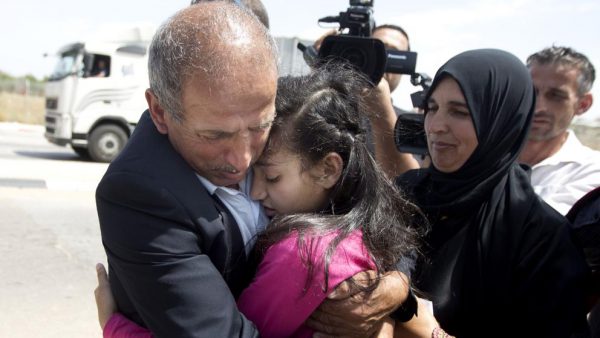 Dima al Wawi se abraza a su padre, ayer en el puesto de control de Jabara, cerca de Tulrkarem, en Cirsjordania (Majdi Mohammed - Majdi Mohammed / AP)
